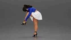 Young woman in skirt adjusts her elegant black high heeled shoes